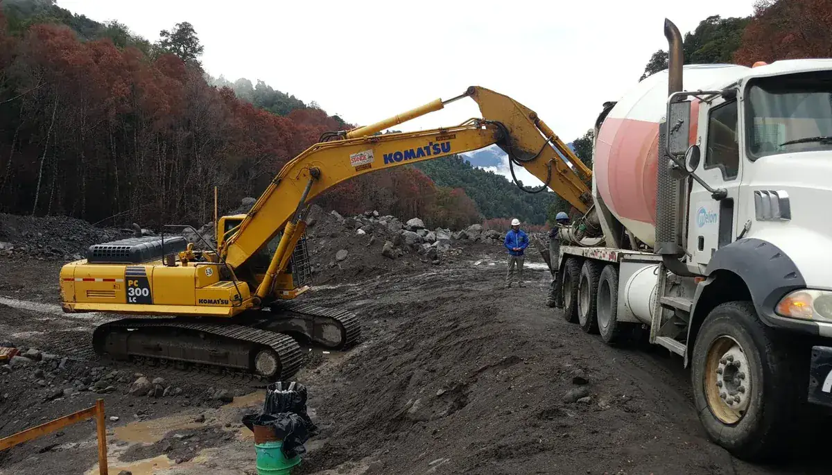 Excavadora y camión hormigonera en obra civil — AL2 Construcciones